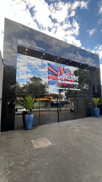 Fachada da London Automotiva em ACM preto brilhante, com a marca aplicada sobre o vidro espelhado