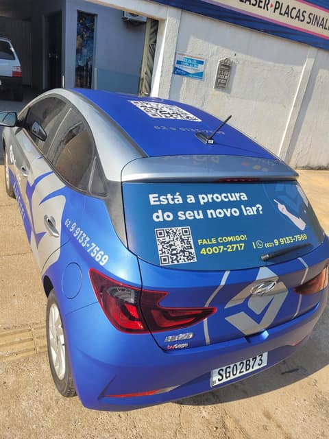 Hatch envelopado em vinil azul, com chamada de campanha e QR code no vidro traseiro