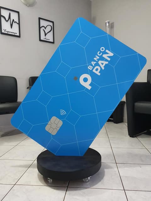 Display de piso do Banco PAN em formato de cartão gigante azul, sobre base circular