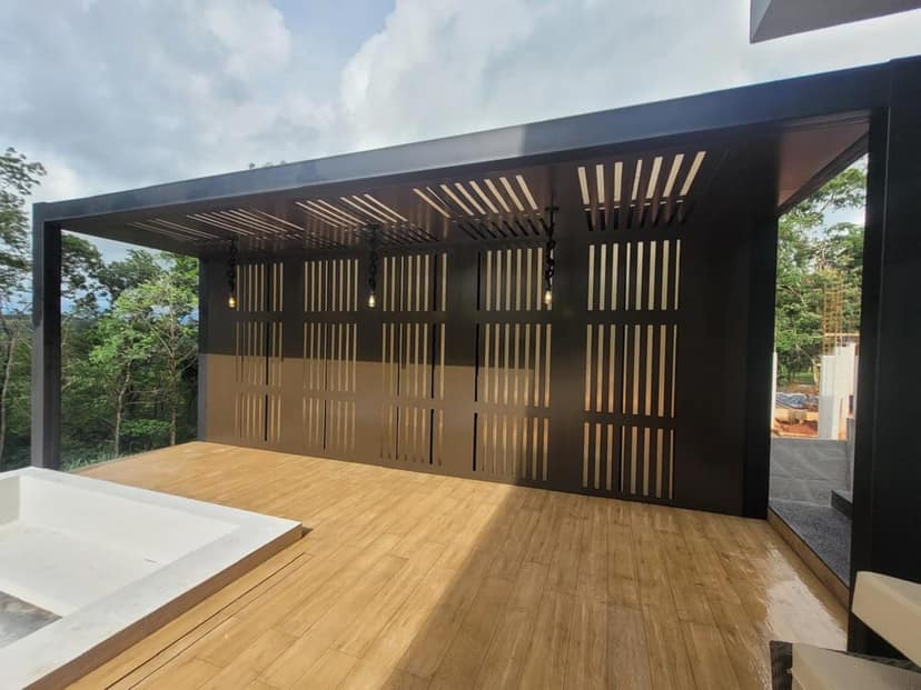 Painel vazado em chapa preta cortada a laser, fechando uma varanda com deck de madeira